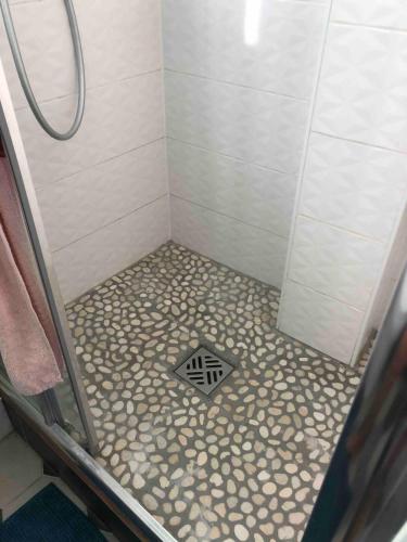 La salle de bains est pourvue d'une douche et de carrelage. dans l'établissement Appartement chaleureux proche Paris, à Montrouge