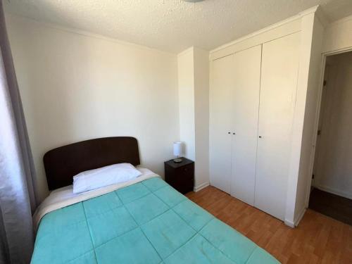 a small bedroom with a bed and a cabinet at Apartamento Altos del Boldo in Curicó