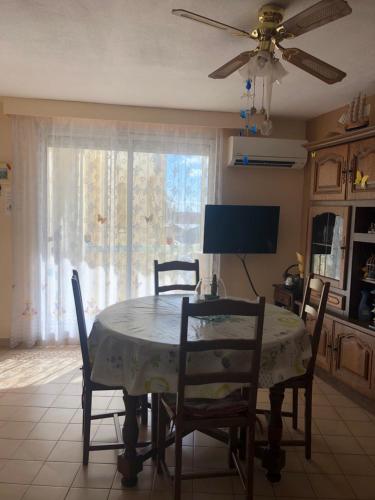 une table à manger avec des chaises et une télévision dans l'établissement Appartement 4 personnes Valras Plage, à Valras-Plage