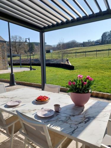 a dining table with a view of a field at Cha Cha de Loup Luxe B&B - Vakantiewoning in Rendeux