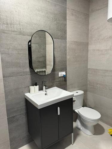 a bathroom with a sink and a toilet and a mirror at La Casa de Rosita in Fuente del Maestre
