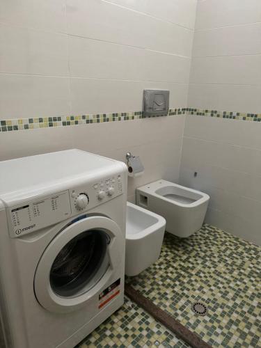 a bathroom with a washing machine and a toilet at Apartament Gjiri i Lalëzit in Draç
