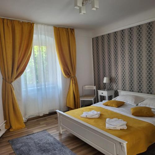 een slaapkamer met een groot bed en een groot raam bij Casa centru vechi sibiu in Sibiu