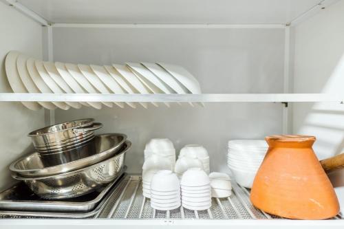 a refrigerator with dishes and a vase on a shelf at 26Villa Huahin in Khao Tao