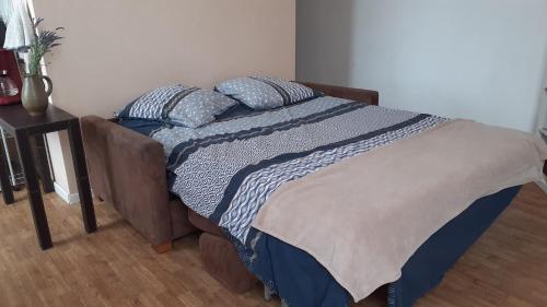 un lit avec des draps et des oreillers bleus et blancs dans l'établissement Studio vue mer 1r étage avec balcon, à Les Sables-dʼOlonne