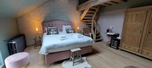 a bedroom with a large bed and a staircase at Cha Cha de Loup Luxe B&B - Vakantiewoning in Rendeux
