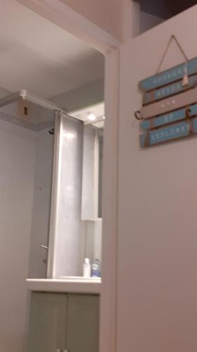 eine weiße Küche mit Spiegel und Spüle in der Unterkunft Studio vue mer 1r étage avec balcon in Les Sables-dʼOlonne