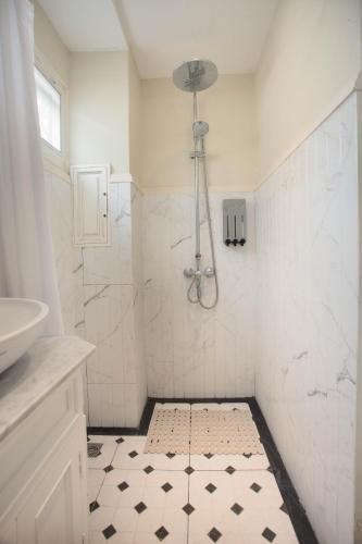a white bathroom with a shower and a sink at Pran At Kumuang Boutique House in Chiang Mai