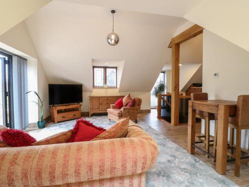 a living room with a couch and a television at The Barn at Catacol in Belper