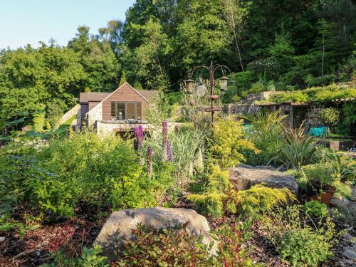 a garden with rocks and plants in front of a house at The Barn at Catacol in Belper