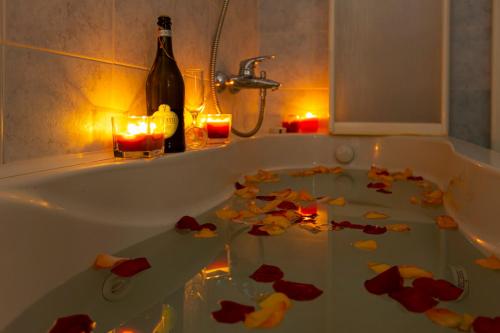 a bathroom with a bath tub filled with leaves and candles at Ad un Passo dal Sole by Le Case di Tati in Sanremo