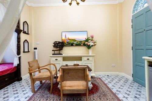 a room with a desk and a chair and a table at Pran At Kumuang Boutique House in Chiang Mai