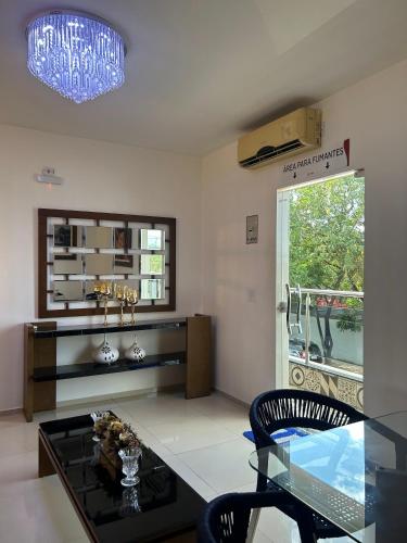 a living room with a glass table and a window at Mais Hotel Express in São Luís