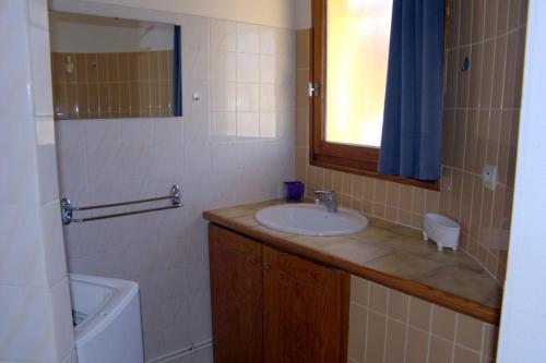 une salle de bain avec un lavabo, des toilettes et un miroir dans l'établissement Maisonnette, à Cazaubon