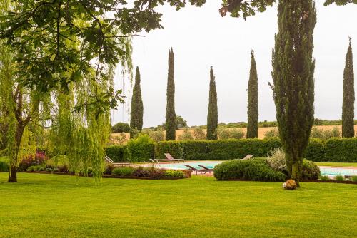 a park with trees and a swimming pool and green grass at Ghiaccio Bosco in Capalbio
