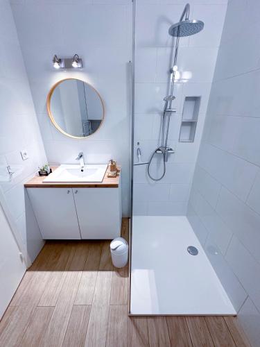 une salle de bain blanche avec une douche et un lavabo dans l'établissement POINCARE 3 - Proche Plage Calme et Rénové à Juan les Pins, à Antibes