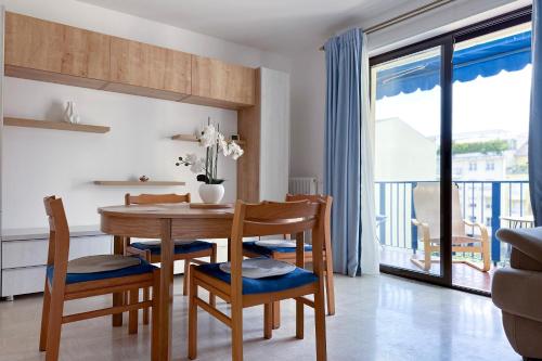 une salle à manger avec une table et des chaises et un balcon dans l'établissement POINCARE 3 - Proche Plage Calme et Rénové à Juan les Pins, à Antibes