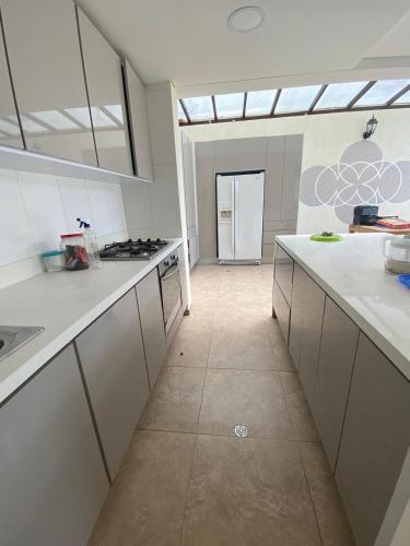 a large kitchen with white counters and a large window at Villa Cony in Pandi