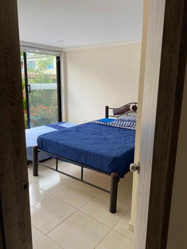 a bedroom with a bed with blue sheets and a window at Villa Cony in Pandi