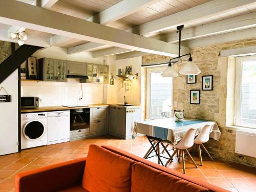une cuisine et une salle à manger avec une table et des chaises dans l'établissement Maison typique Oléronaise au cœur de l'île d'Oléron, à Saint-Georges-dʼOléron