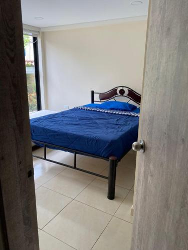 a bedroom with a bed with a blue comforter at Villa Cony in Pandi