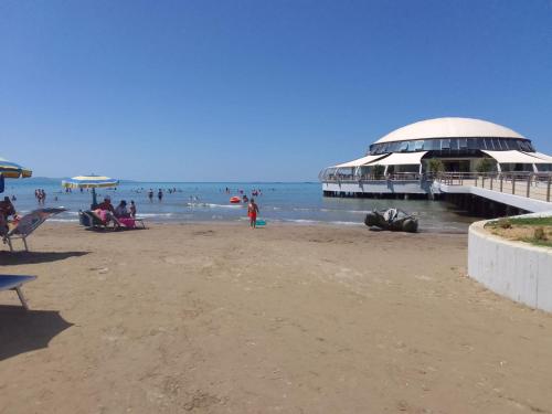 a group of people on a beach with a pier at Villa Xhelalit large ensuite rooms in Durrës