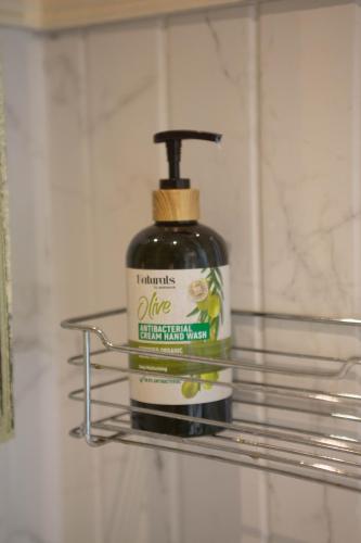 a bottle of cleaning agent on a shelf in a bathroom at Pran At Kumuang Boutique House in Chiang Mai