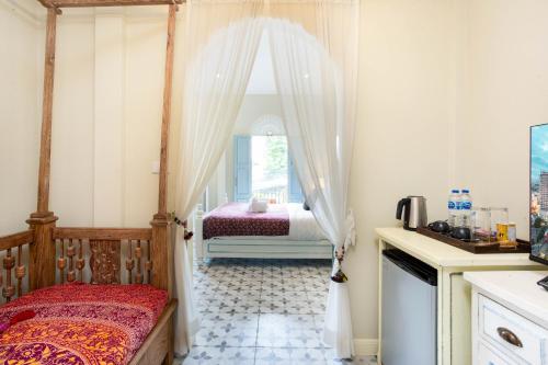a bedroom with a bed and a window at Pran At Kumuang Boutique House in Chiang Mai