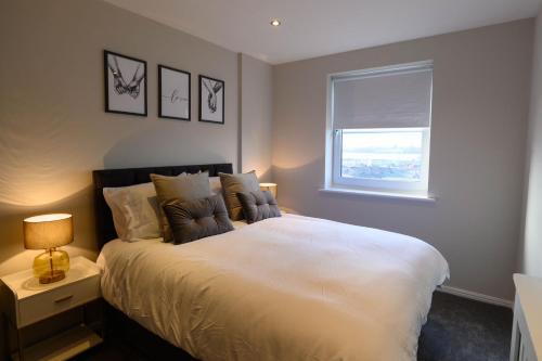 a bedroom with a large white bed with a window at Stunning Liverpool City Location with River View and parking space included in Liverpool