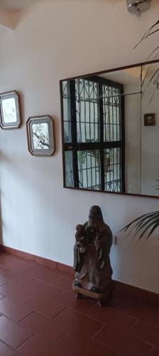 a statue sitting on the floor in front of a mirror at 7 Olmi b&b Bologna in Carteria di Sesto Rastignano
