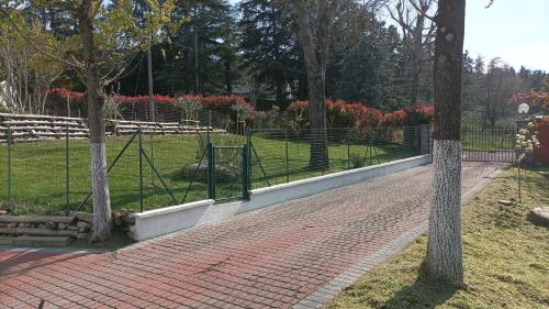 a fence in a park with trees and a brick sidewalk at 7 Olmi b&b Bologna in Carteria di Sesto Rastignano
