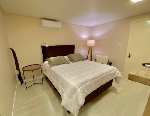 a bedroom with a large bed and a table at Rodeio Hotel in Rodeio Bonito
