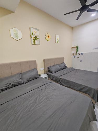 a bedroom with two beds and a ceiling fan at Melaka privatepool bungalow BBQWIFI krubong in Malacca