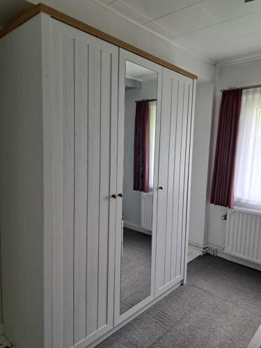a bedroom with white closet doors and a mirror at Vitus-Perle in Saint-Vith