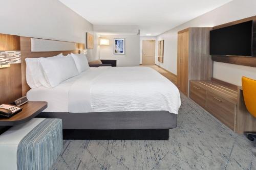 a hotel room with a large bed and a desk at Holiday Inn Express & Suites Port Washington by IHG in Port Washington