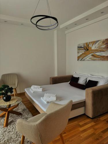 a bedroom with a bed and a table and chairs at HelVik Apartman Aqua Park in Vrnjačka Banja