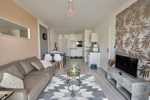 un salon avec un canapé et une table dans l'établissement Appartement passage à 10 mins de Charles De Gaulle, proche parc d'exposition, à Villepinte