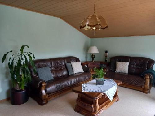 a living room with two leather couches and a table at Martina in Saint-Vith