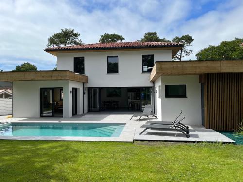 une maison avec une piscine dans la cour dans l'établissement Villas-des-oyats - Arena - 8 personnes climatisée piscine chauffée, à Seignosse