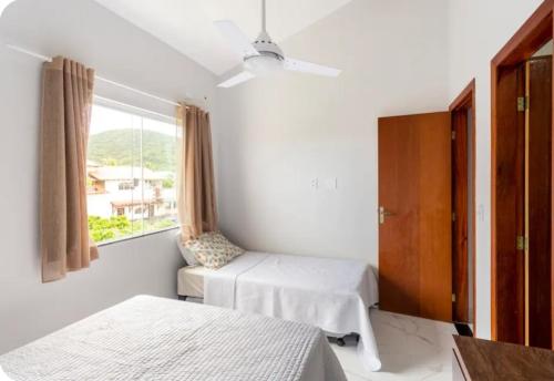 a bedroom with two beds and a window at Triplex Belíssimo in Cabo Frio
