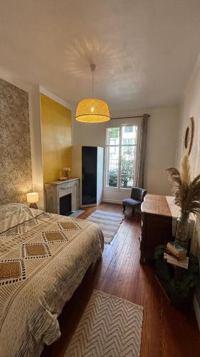 une chambre avec un lit, un bureau et une fenêtre dans l'établissement Appartement - Cannes proche Croisette avec jardin, à Cannes