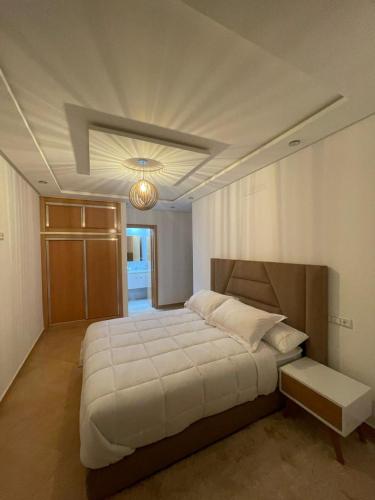 a bedroom with a large bed and a ceiling at Timitar, your own Cozy apartment in Agadir
