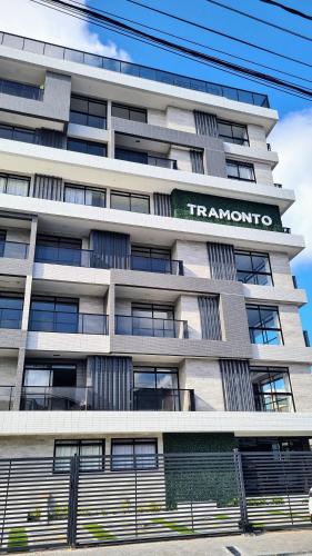 a tall white building with a sign on it at Flats Tramonto - By EasyHost in João Pessoa