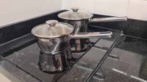 two pots sitting on top of a stove at Flats Tramonto - By EasyHost in João Pessoa