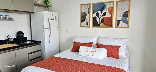 a small kitchen with a bed with red and white pillows at Flats Tramonto - By EasyHost in João Pessoa