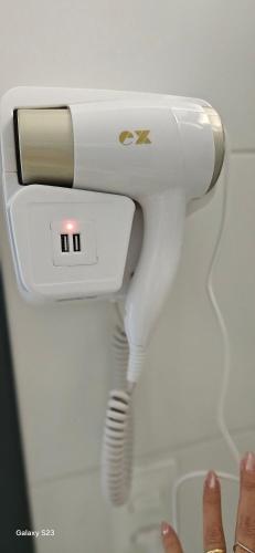 a white hair dryer hanging on a wall at Flats Tramonto - By EasyHost in João Pessoa