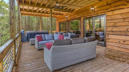 a porch of a log cabin with couches and chairs at 4 Leaf Clover in Blue Ridge