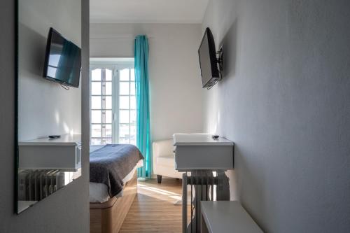 a bedroom with a bed and a television on a wall at EnSuite 1 Azul Rochedo in Santo Isidoro