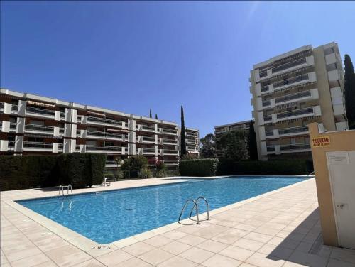 - une piscine en face de deux immeubles d'appartements dans l'établissement Appartement biaritz, à Saint-Raphaël