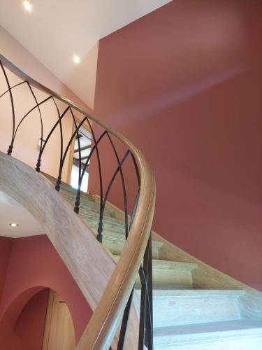 a spiral staircase in a house with orange walls at Cha Cha de Loup Luxe B&B - Vakantiewoning in Rendeux